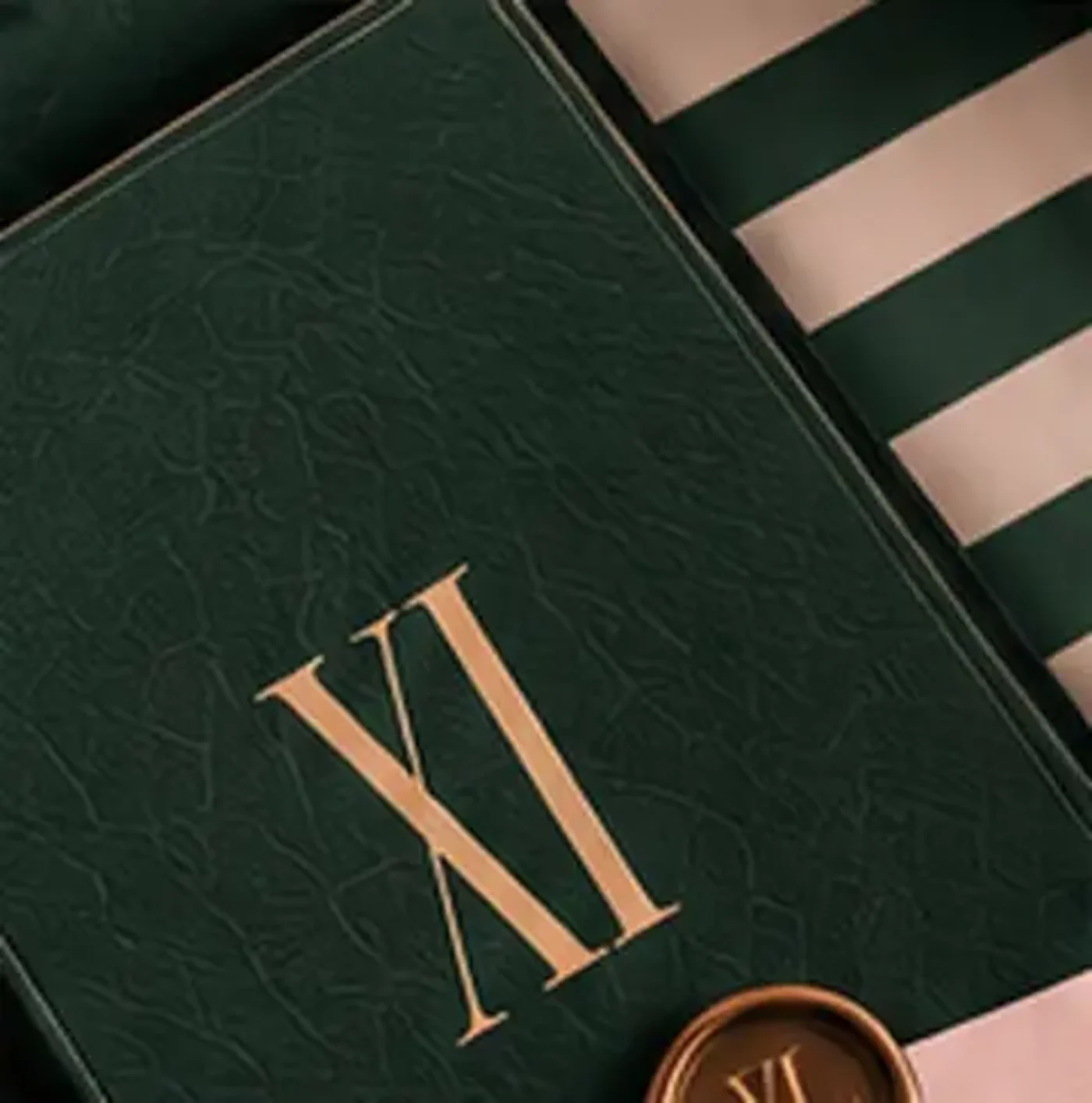 An evergreen folio with a gold XI and a wax seal on striped linen