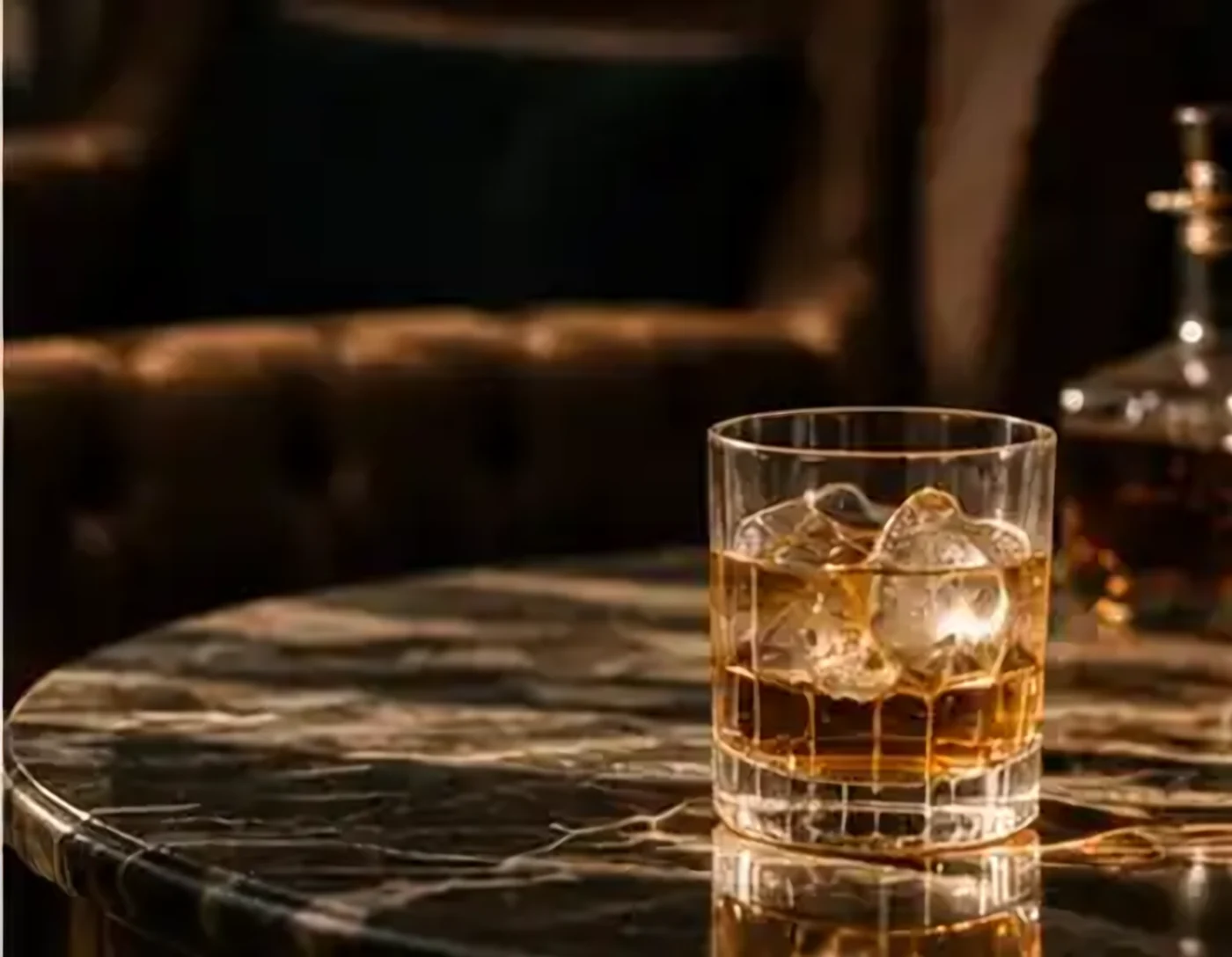 A whisky on ice on a marble table in a dark lounge